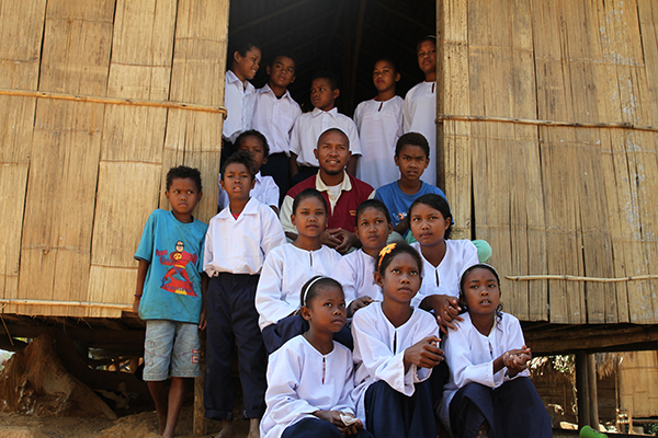 The children of Kampung Chuweh and their teacher, Askee on the steps of the Learning